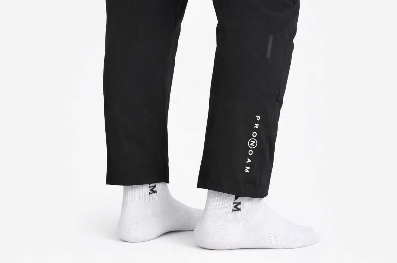 stylish black men’s sports trousers featuring the PRONOAM logo on the upper thigh. The pants have a modern, tapered fit designed for both. athletic performance and casual fashion. Zipper 