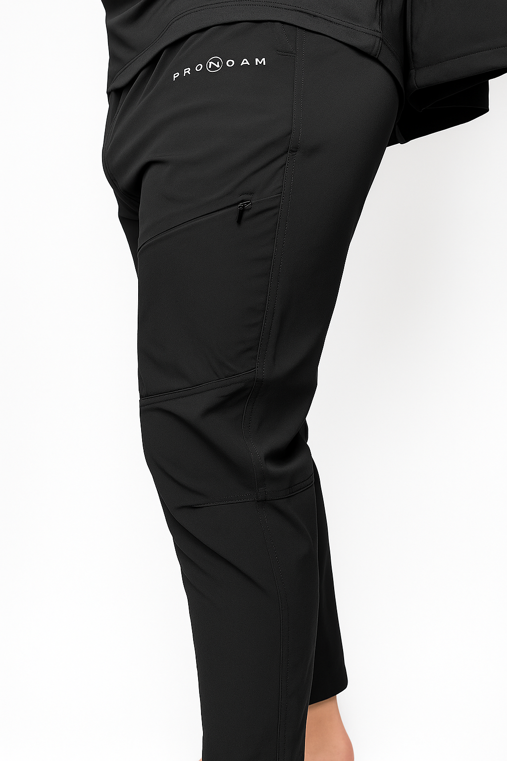 Men's black PRONOAM athletic trousers featuring a tapered leg, performance zip pockets, and signature white branding. Stylish men's gym pants and activewear.