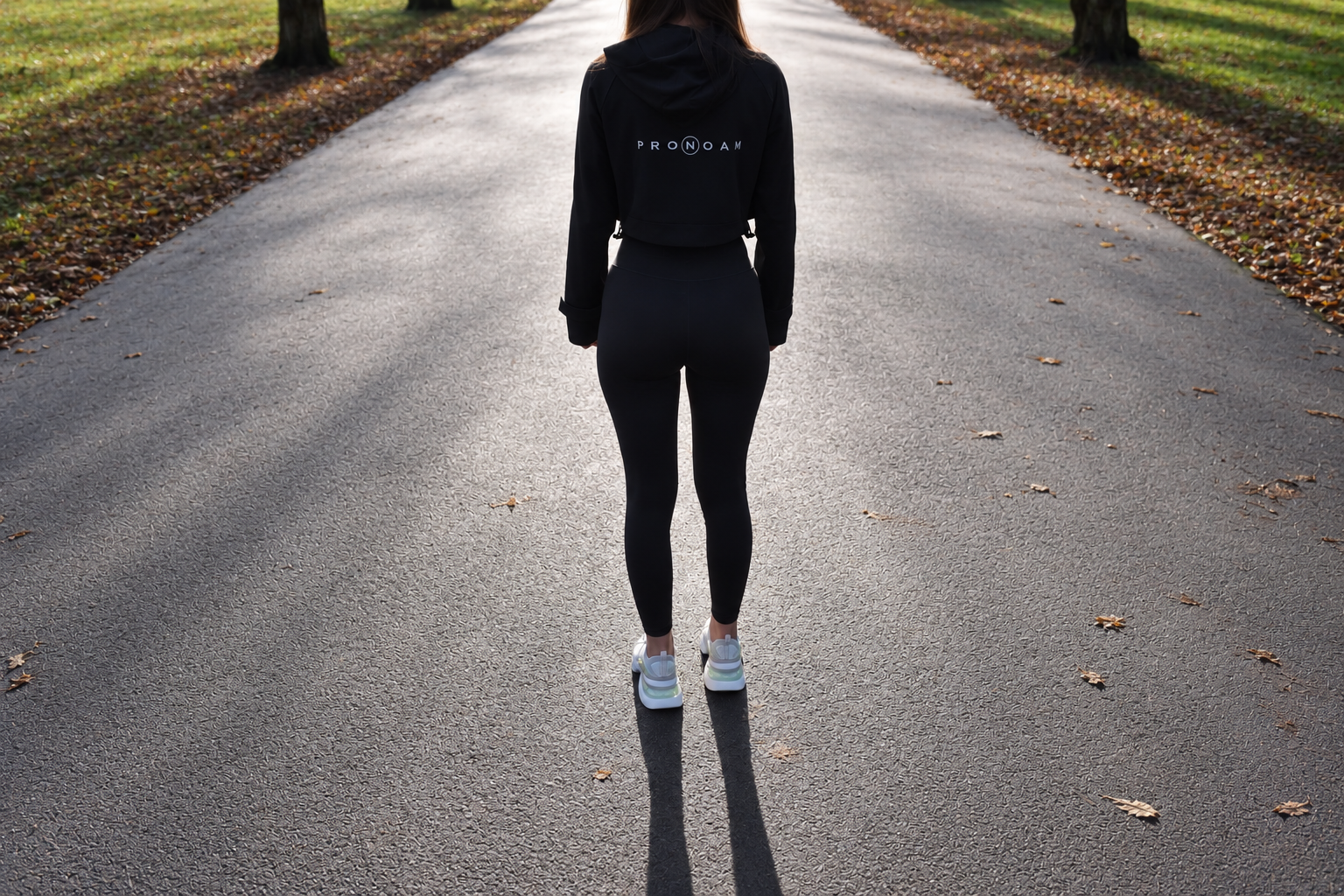 A clothing tag for PRONOAM premium sport fashion wear, including text for gym casual and dressy sportswear, alongside a circular logo featuring the letter "N". PRONOAM Designer Athleisure Dressy Sportswear & Premium Gym Fashion Apparel